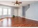 Bright living room with hardwood floors, bay window, ceiling fan, and staircase at 125 Watertree Ln, Apex, NC 27502