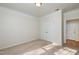 Neutral carpeted bedroom with natural lighting from window and a closet at 1300 Durlain Dr # 108, Raleigh, NC 27614