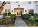 Condo entrance with a brick archway, glass door, address, and mature landscaping framing the walkway at 1300 Durlain Dr # 108, Raleigh, NC 27614