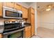 Kitchen with stainless steel microwave and stove, natural-toned wood cabinets and granite countertops at 1300 Durlain Dr # 108, Raleigh, NC 27614