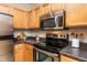 Kitchen features stainless steel appliances, natural-toned wood cabinets and granite countertops at 1300 Durlain Dr # 108, Raleigh, NC 27614