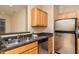Kitchen with stainless steel sink and appliances, granite countertops, and natural-toned wood cabinets at 1300 Durlain Dr # 108, Raleigh, NC 27614