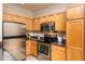 Kitchen showcasing stainless steel appliances, granite countertops, and natural wood cabinets at 1300 Durlain Dr # 108, Raleigh, NC 27614