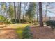 Landscaped side yard with tall trees and green grass at 2801 Chelsea Cir, Durham, NC 27707