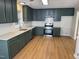 Updated kitchen with green cabinets, quartz countertops, and stainless steel appliances at 3212 Potthast Ct, Raleigh, NC 27616
