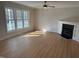 Bright living room featuring a modern fireplace, wood floors, and an abundance of natural light from multiple windows at 3212 Potthast Ct, Raleigh, NC 27616