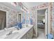 Bathroom with floral wallpaper, double sinks, and ample counter space, blending vintage charm with functionality at 3347 Ridgecrest Ct, Raleigh, NC 27607