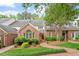 Beautiful brick home with a well-manicured lawn and mature trees on a sunny day at 3347 Ridgecrest Ct, Raleigh, NC 27607