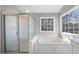 Bathroom featuring a glass enclosed shower, a tub and a window at 4703 Paces Ferry Dr, Durham, NC 27712