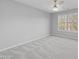 Neutral bedroom featuring a large window and soft carpet at 4703 Paces Ferry Dr, Durham, NC 27712