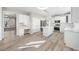 Modern kitchen with white cabinets, island, stainless appliances, and luxury vinyl plank flooring at 4703 Paces Ferry Dr, Durham, NC 27712