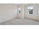 Carpeted bedroom with two windows offering natural light and neighborhood views at 4804 Cypress Tree Ln, Raleigh, NC 27612