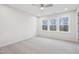 Bright bedroom with neutral carpet, a ceiling fan, and a large window offering natural light at 4804 Cypress Tree Ln, Raleigh, NC 27612
