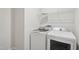 Laundry room area featuring a white washer and dryer, shelving, and patterned tile floors at 4804 Cypress Tree Ln, Raleigh, NC 27612