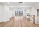 Open-plan living room with hardwood floors, a fireplace, a sliding glass door and staircase at 4804 Cypress Tree Ln, Raleigh, NC 27612