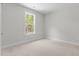 Bedroom featuring neutral carpet and paint, and a single window for natural light at 50 Arbor Dr, Youngsville, NC 27596
