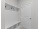 A functional mudroom offers storage with hooks and seating, next to a white door at 50 Arbor Dr, Youngsville, NC 27596