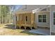 Rear exterior view of a beige home featuring a wooden back porch with steps to yard at 50 Arbor Dr, Youngsville, NC 27596