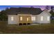 Exterior shot of backyard at dusk, complete with a wooden porch and neutral siding at 50 Arbor Dr, Youngsville, NC 27596