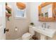 Half bathroom with wooden-framed mirror, pedestal sink, commode and stylish window shade at 7700 Circle L Trl, Rougemont, NC 27572