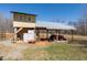 Equipment shed with a covered area for tractor and a storage area with stacked materials at 7700 Circle L Trl, Rougemont, NC 27572