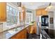 Kitchen featuring wooden cabinets, granite countertops, stainless steel appliances and large windows at 7700 Circle L Trl, Rougemont, NC 27572