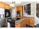 Kitchen area featuring wood cabinets, a wine rack, an island cooktop, and stainless steel appliances at 7700 Circle L Trl, Rougemont, NC 27572