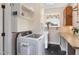 Laundry area with front loading machines, cabinets, folding counter and natural light at 7700 Circle L Trl, Rougemont, NC 27572