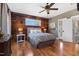 Cozy bedroom with hardwood floors, wood accent wall, and ample natural light at 7700 Circle L Trl, Rougemont, NC 27572