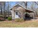 Small outbuilding with covered storage, white door, and natural climbing vines for a rustic touch at 7700 Circle L Trl, Rougemont, NC 27572