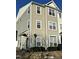 Three-story tan building with multiple windows and a black door at 1211 Canyon Rock Ct # 111, Raleigh, NC 27610