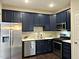 Modern kitchen features stainless steel appliances, white countertops, dark cabinets and sleek backsplash at 1211 Canyon Rock Ct # 111, Raleigh, NC 27610