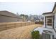Spacious backyard featuring a well-maintained lawn, a black metal fence, and a screened porch addition to the home at 12408 Angel Vale Pl, Durham, NC 27703