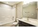Well-lit bathroom featuring a shower-tub combo with white tile, a single sink vanity, and neutral wall colors at 12408 Angel Vale Pl, Durham, NC 27703