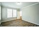 Bright bedroom featuring luxury vinyl flooring, neutral walls and multiple windows at 12408 Angel Vale Pl, Durham, NC 27703