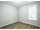 Cozy bedroom featuring modern luxury vinyl flooring and a bright window at 12408 Angel Vale Pl, Durham, NC 27703
