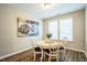 Cozy dining area with a round table, four chairs, neutral walls, and an artful painting at 12408 Angel Vale Pl, Durham, NC 27703