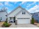 Charming white home featuring a two-car garage, a welcoming front porch, and well-maintained landscaping at 12408 Angel Vale Pl, Durham, NC 27703