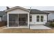 Charming white home with a screened-in porch, a patio, and a lush lawn for outdoor enjoyment at 12408 Angel Vale Pl, Durham, NC 27703