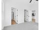 Bedroom with grey carpet, ceiling fan, and access to two closets and a full bathroom at 203 Royal St, Fuquay Varina, NC 27526