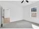 Bright bedroom with grey carpet, ceiling fan and access to a bathroom and hallway at 203 Royal St, Fuquay Varina, NC 27526