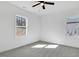 Bright bedroom with grey carpet, ceiling fan, and two large windows at 203 Royal St, Fuquay Varina, NC 27526