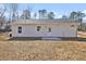 Rear view of a single-story house with a patio and grassy yard at 203 Royal St, Fuquay Varina, NC 27526