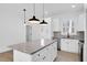 Modern kitchen with white cabinets, granite island, and stainless steel appliances at 203 Royal St, Fuquay Varina, NC 27526