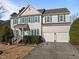 Two-story house with green shutters, double garage, and manicured lawn at 203 Stoney Dr, Durham, NC 27703