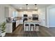 Virtually staged kitchen with white cabinets, granite counters, and an island at 209 Danube Dr, Zebulon, NC 27597