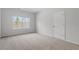 Spacious bedroom with neutral carpet, a window with backyard views, and a white door at 209 Meadowbark Bnd # 20, Garner, NC 27529