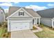 Stylish home with a two-car garage, attractive gray siding, and a neatly landscaped yard, blending comfort and style at 209 Meadowbark Bnd # 20, Garner, NC 27529