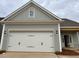 Exterior view featuring a two-car garage with a white door and gray siding at 209 Meadowbark Bnd # 20, Garner, NC 27529