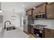 Modern kitchen showcasing stainless steel appliances, white backsplash, quartz countertop, and dark brown cabinets at 209 Meadowbark Bnd # 20, Garner, NC 27529